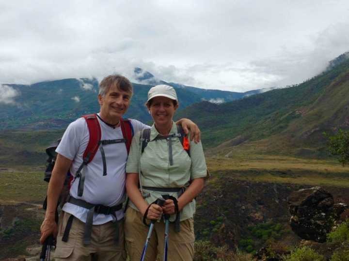 Two hikers standing together in a mountain valley
