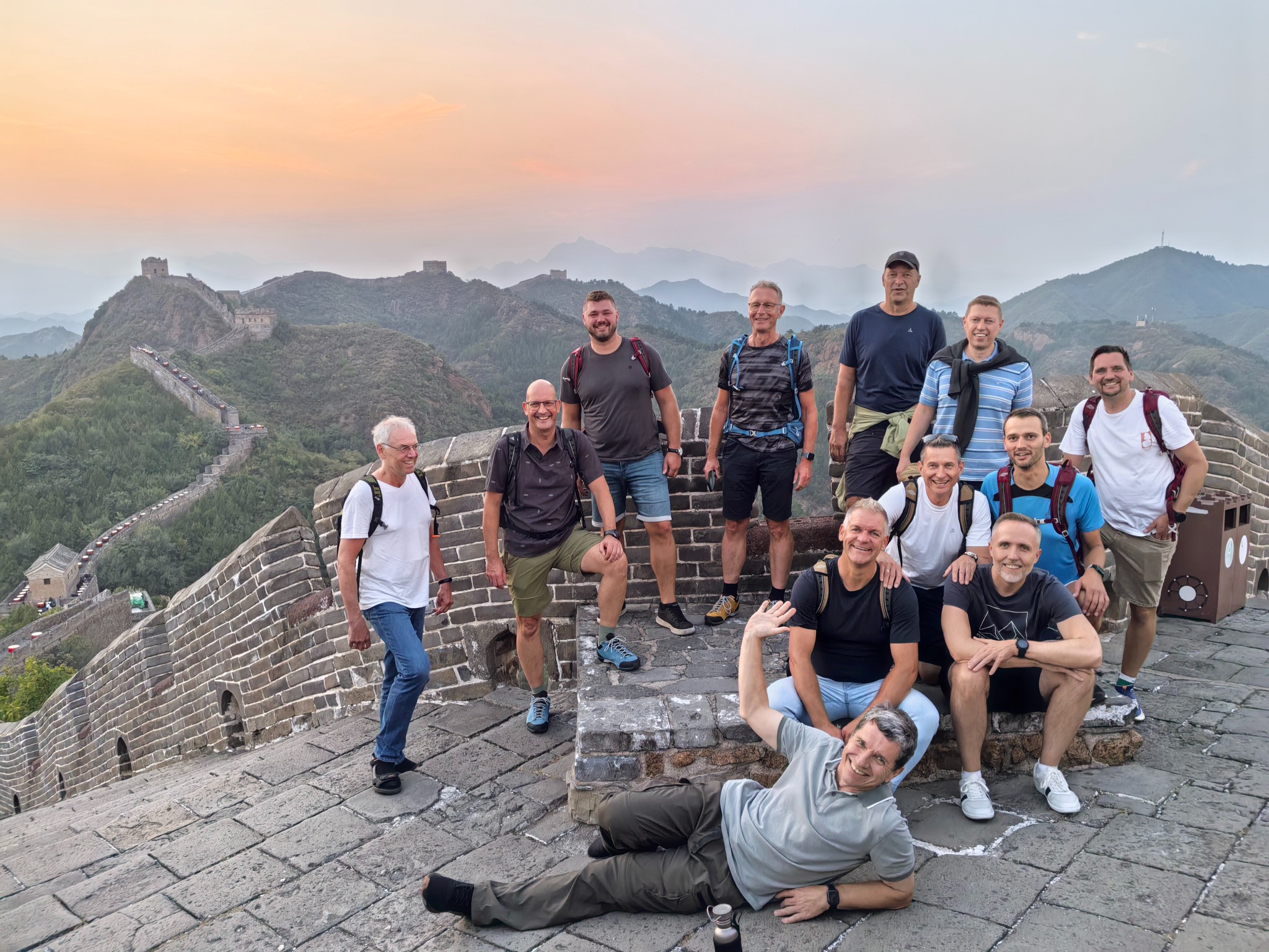 Traveler group posing on the Great Wall at sunset